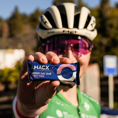 Elisa Longo Borghini dégustant une barre énergétique Amacx aux figues douces, un produit vegan fournissant 30 grammes de glucides.